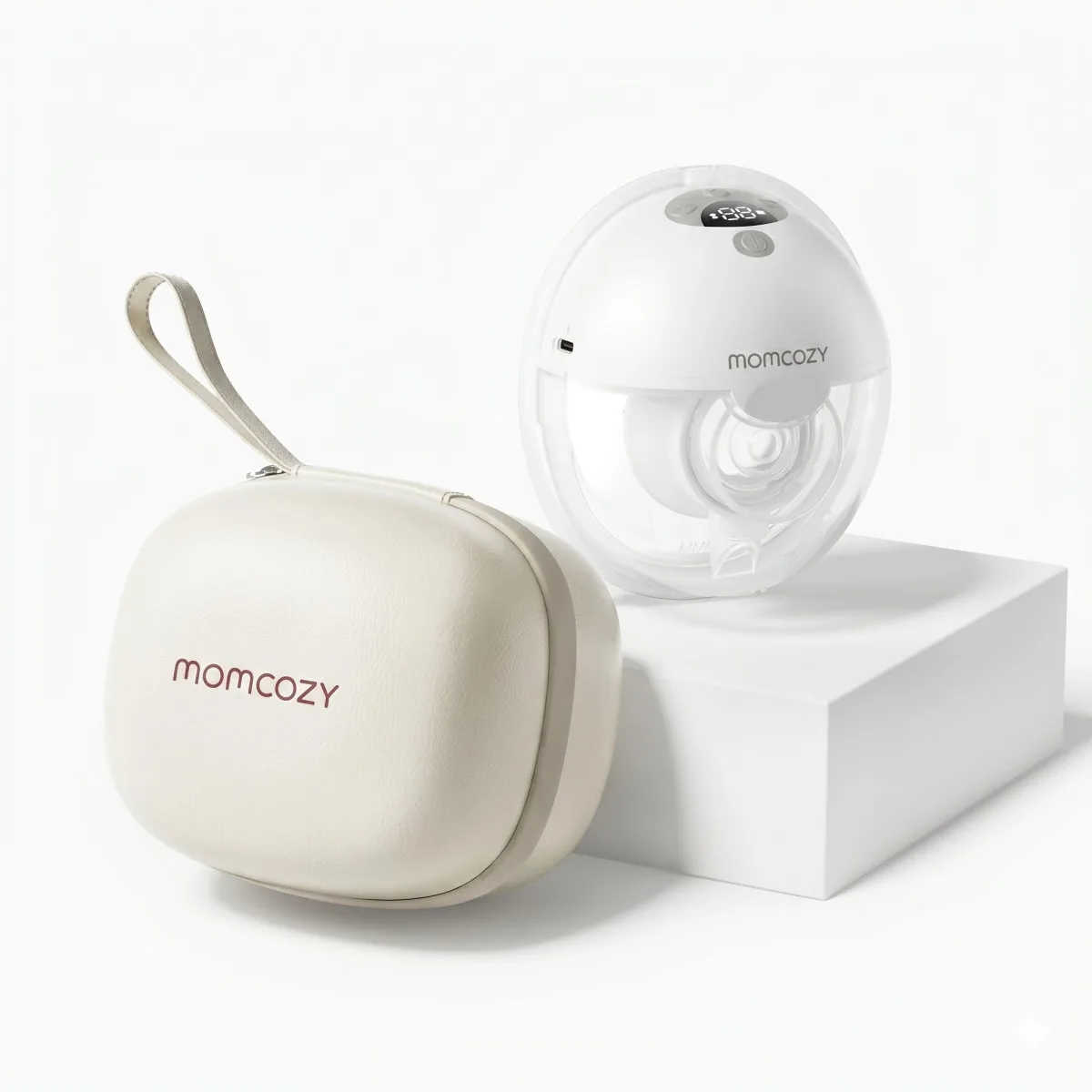 Sistema portátil de extracción con estuche de almacenamiento, marca Momcozy. Modelo M5 Smart. Extractor de leche materna portátil junto a su estuche de transporte, ambos en tonos blancos y sobre una superficie minimalista.